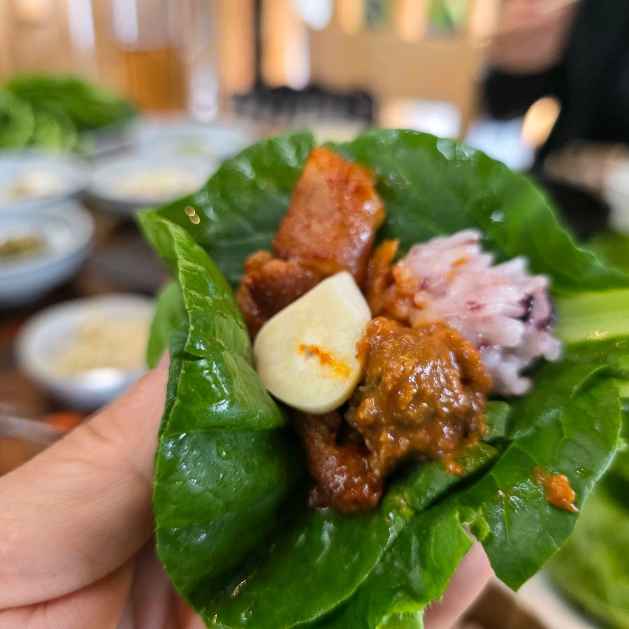 쌈 채소에 밥과 고기를 올려 한 입 가득