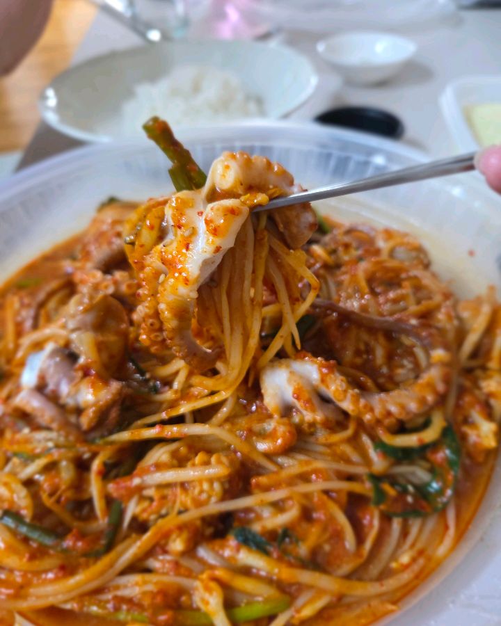 젓가락으로 집어 올린 아구찜과 콩나물