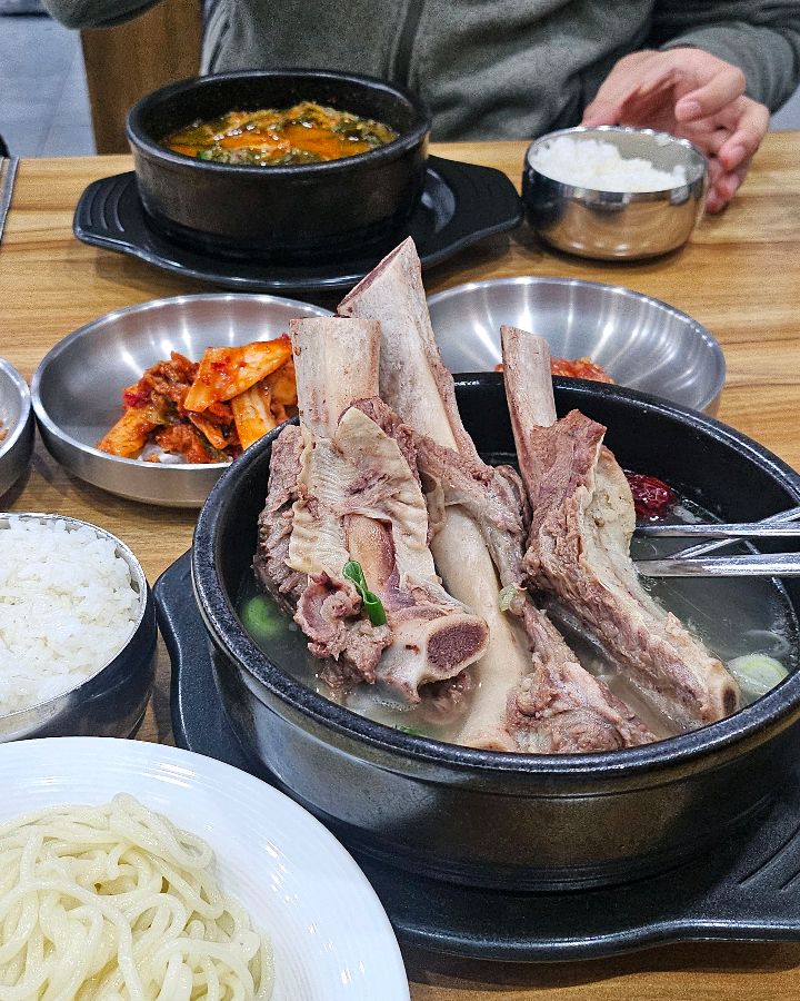 갈비탕, 밥, 반찬이 모두 차려진 테이블 전경