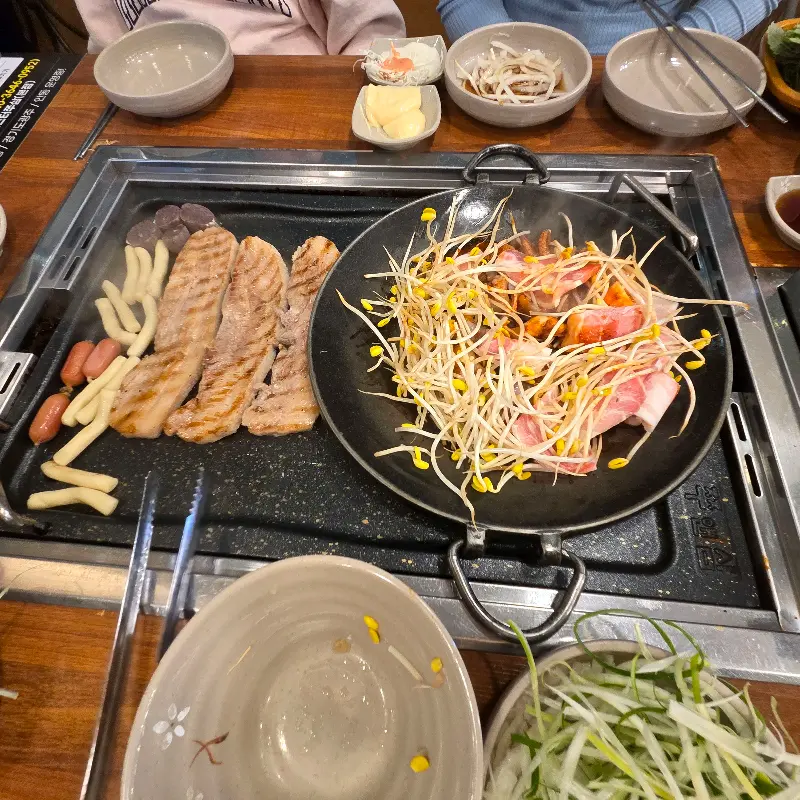 쭈꾸미, 삼겹살, 소세지, 콩나물 등이 푸짐하게 담긴 불판 전체샷