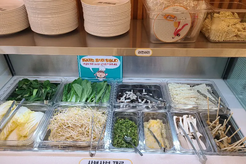 다양한 샤브샤브 재료들이 깔끔하게 정돈되어 있는 샐러드바 모습