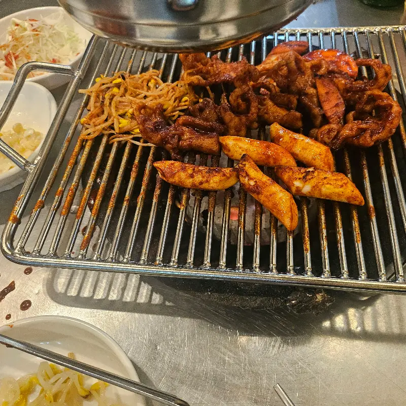 연탄불 위에 닭발과 함께 구워지는 떡