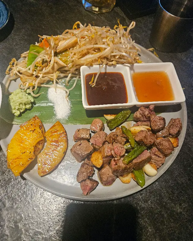 스테이크와 야채, 소스가 가지런히 담겨 있는 접시