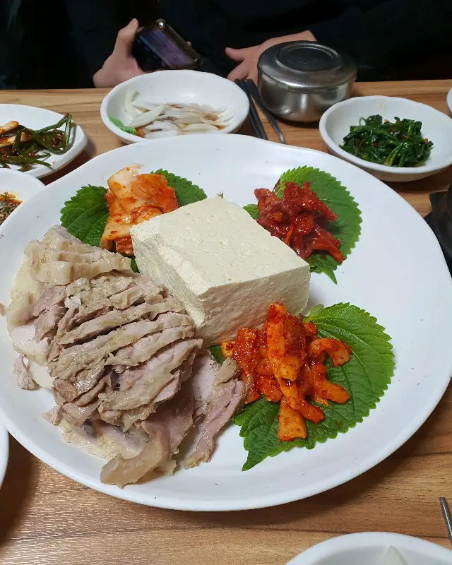 깻잎 위에 보쌈, 두부, 김치를 올려 한 입에