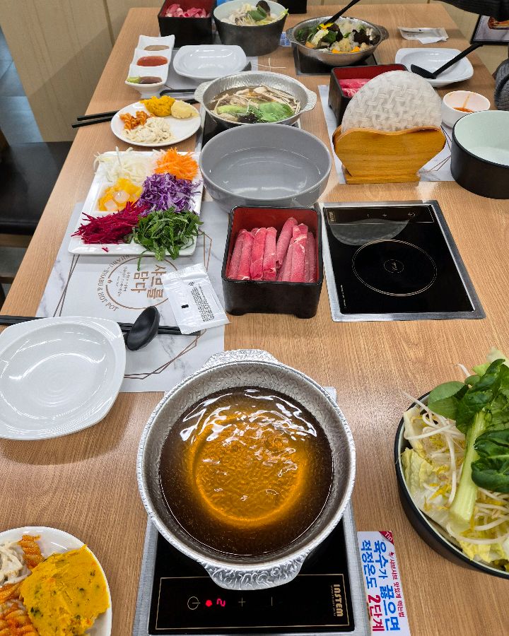 테이블 가득 샤브샤브 재료와 월남쌈 재료가 차려진 모습
