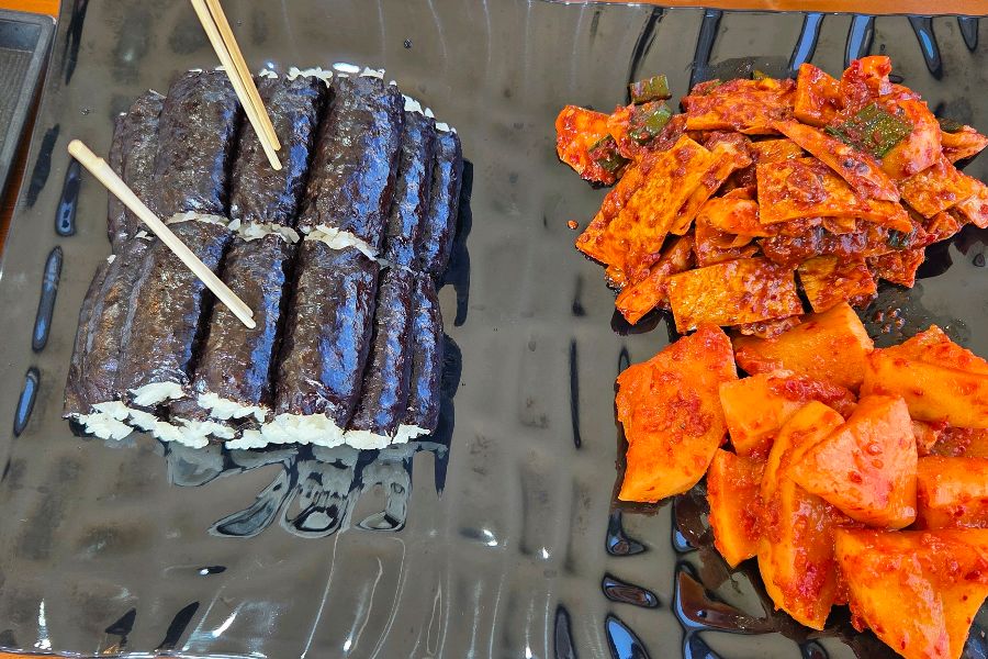 윤기가 자르르 흐르는 충무김밥과 먹음직스러운 오징어 무침, 석박지