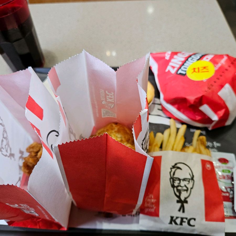 쟁반 위에 놓인 치킨, 버거, 감자튀김, 콜라