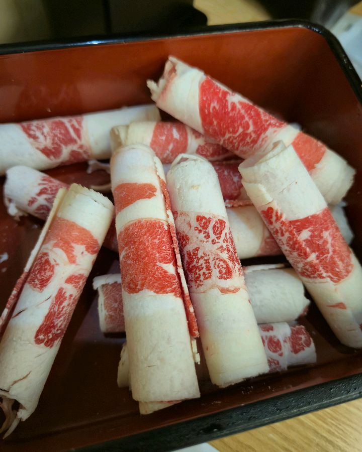 얇게 슬라이스된 양지 고기가 붉은 빛깔을 뽐내며 가지런히 담겨 있다.