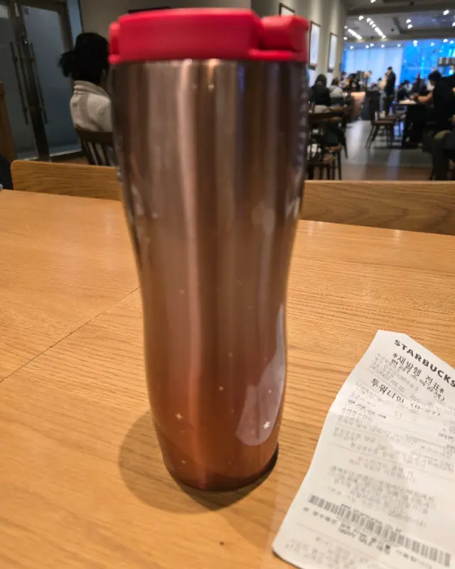 테이블 위에 놓인 텀블러와 영수증