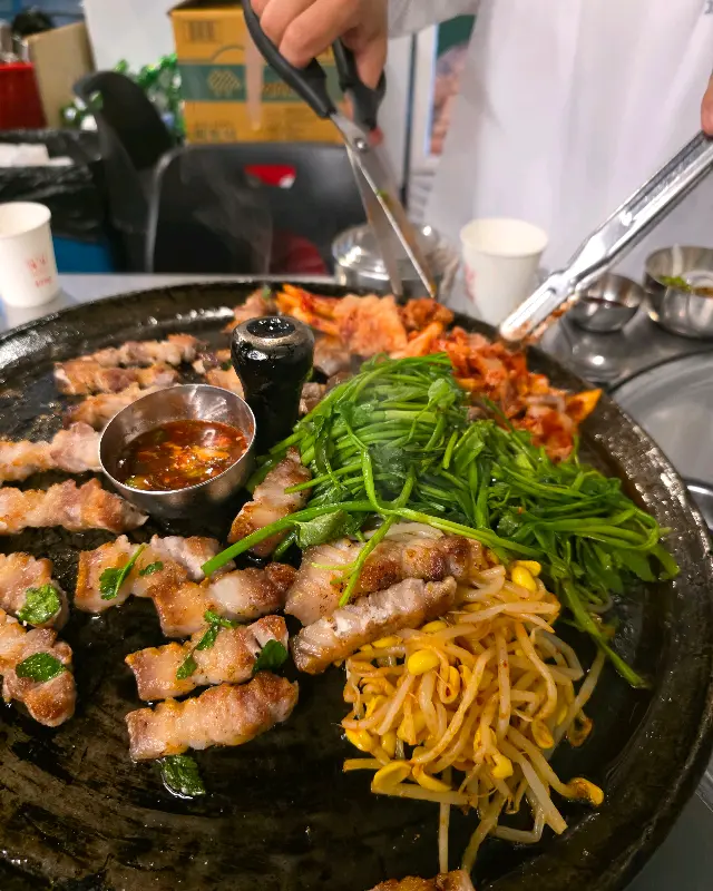 직원이 능숙한 솜씨로 삼겹살을 굽고 있는 모습