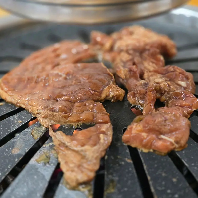숯불 위에서 노릇하게 익어가는 돼지갈비