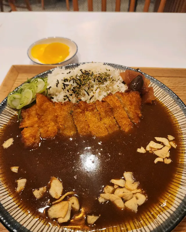 돈까스 카레의 모습, 밥 위에 돈까스와 김가루가 얹혀져 있고 주변에는 카레 소스가 넉넉하게 둘러져 있다.