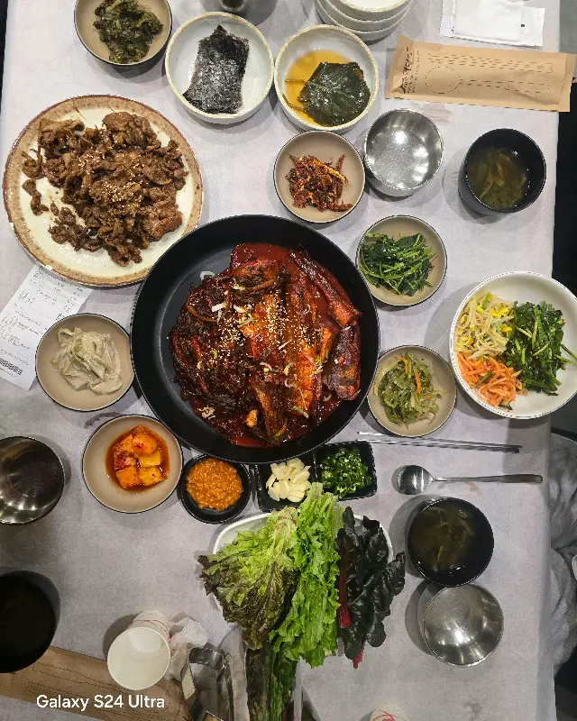 돼지불백과 코다리찜, 다양한 반찬들이 푸짐하게 차려진 테이블 전경