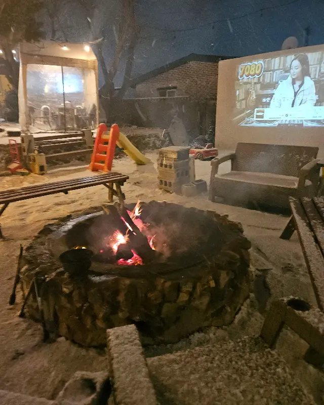 모닥불 주변에 눈이 쌓인 풍경