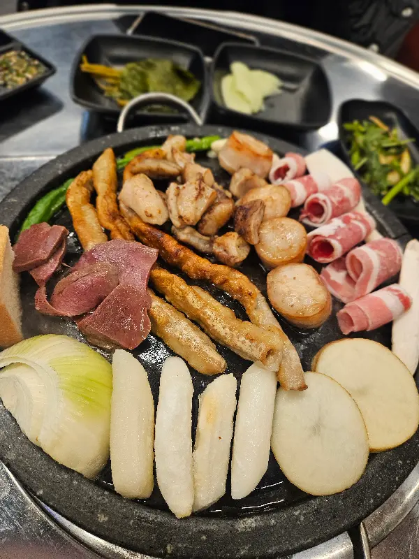 돌판 위에 구워진 곱창, 대창, 막창과 다양한 곁들임