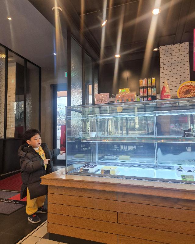 케이크 쇼케이스를 구경하는 아이