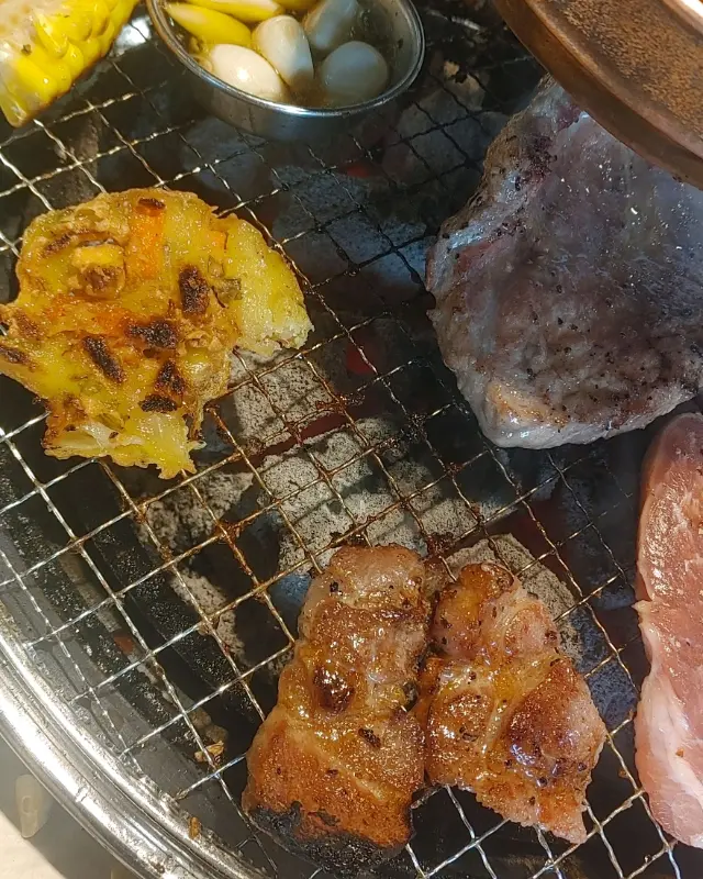 불판 위에서 구워지고 있는 고기와 마늘