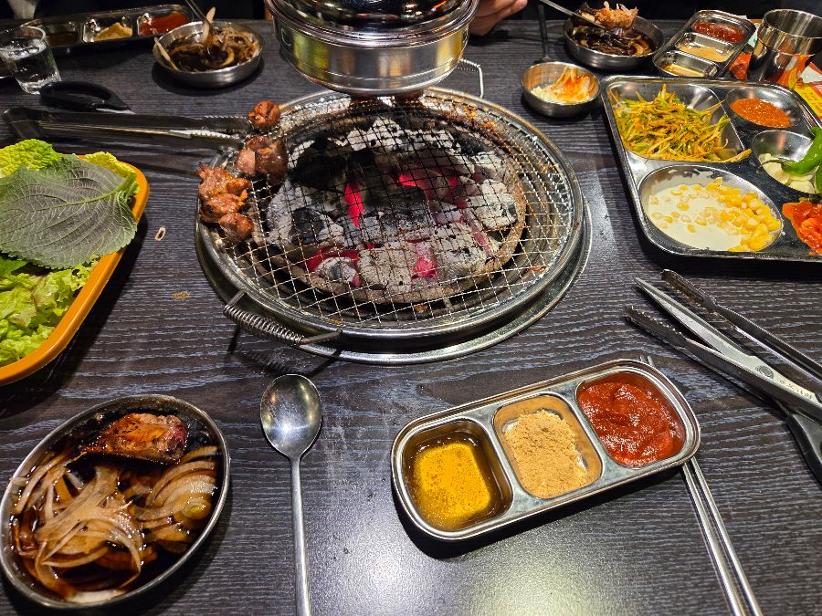 푸짐하게 차려진 테이블 위 숯불구이 한 상