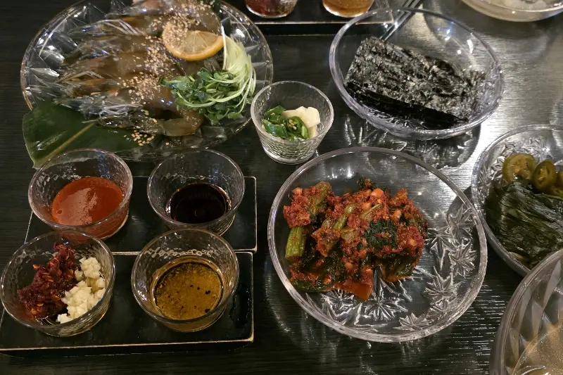 다채로운 밑반찬이 정갈하게 담겨 쟁반 위에 놓여 있는 모습