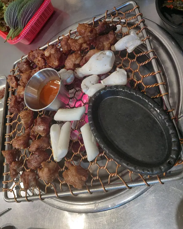 숯불 위에서 익어가는 뽈살과 떡