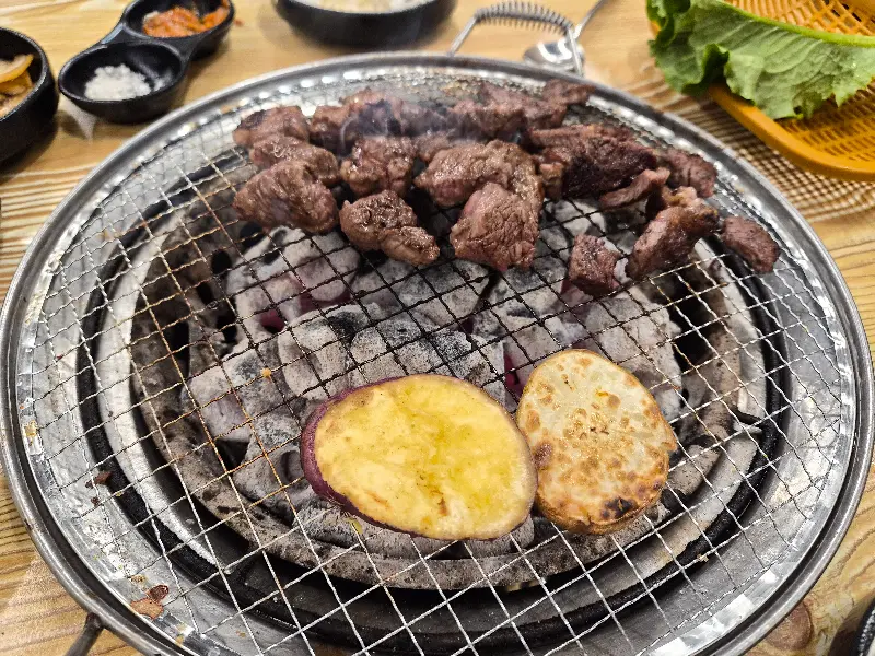 숯불 위에서 익어가는 소고기와 고구마
