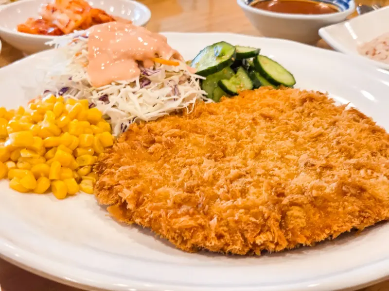 돈까스, 김치, 샐러드, 밥이 한 접시에 담겨 있는 모습