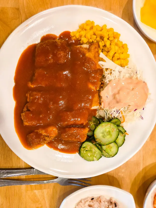 돈까스 위에 소스가 듬뿍 뿌려진 모습