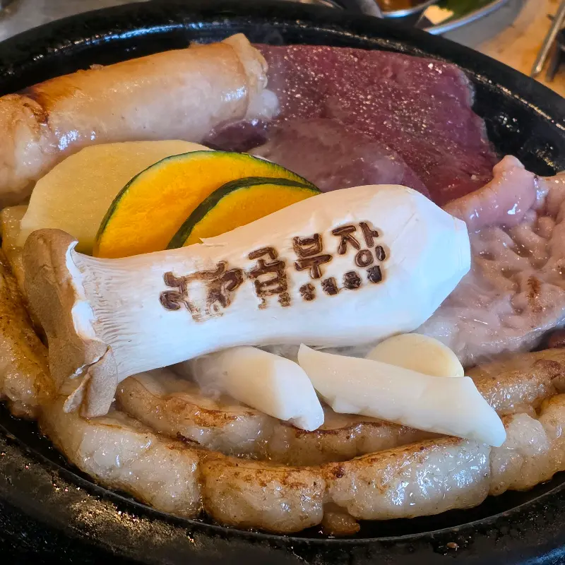 곱부장 상호가 새겨진 버섯과 곱창, 막창, 염통이 함께 구워지는 모습