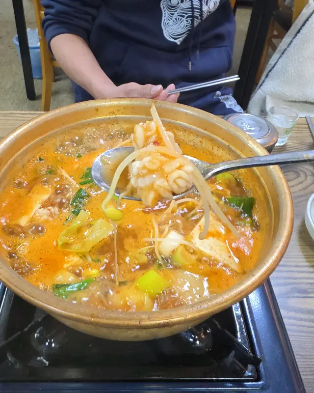 섞어탕을 숟가락으로 뜨는 모습