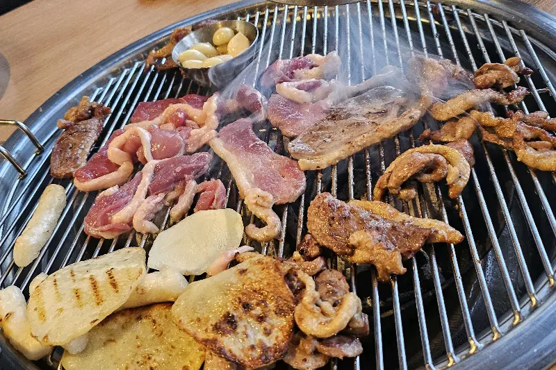 숯불 위에서 노릇하게 익어가는 오리고기