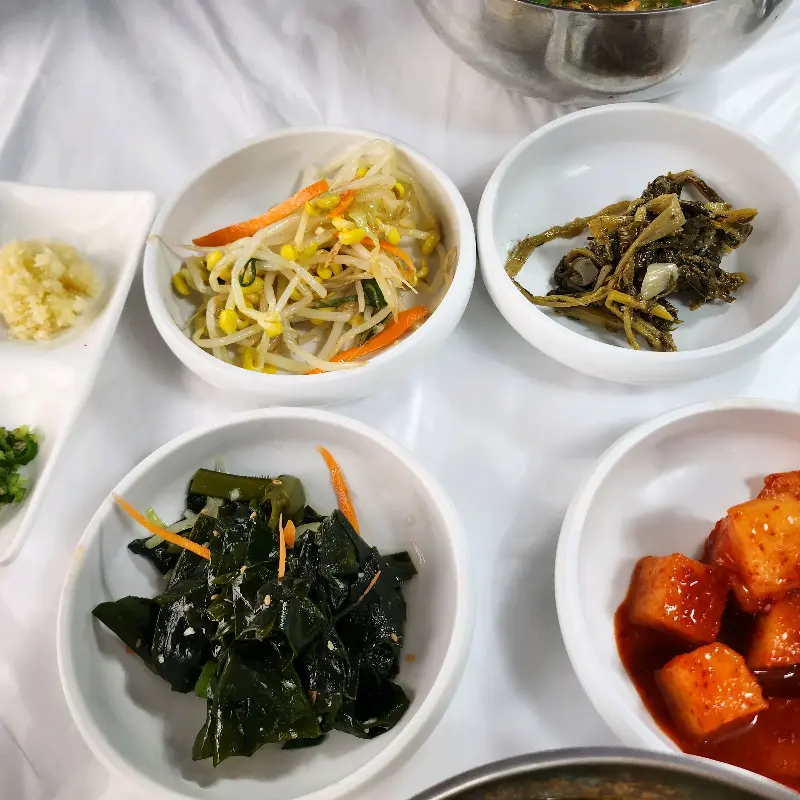 정갈하게 담겨 나온 밑반찬들의 모습. 콩나물, 깍두기, 해초 무침 등이 제공된다.
