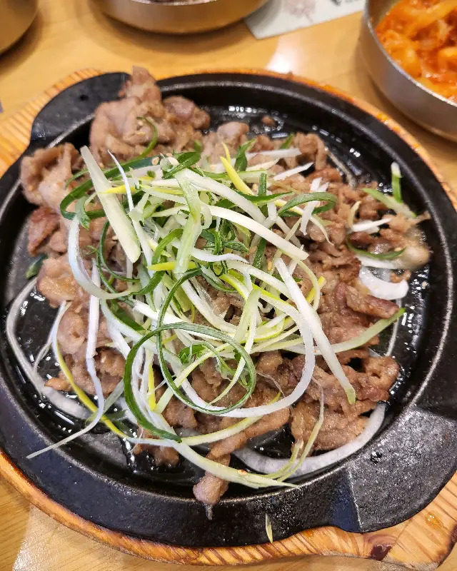 다양한 쌈채소와 함께 제공되는 윤기나는 보쌈