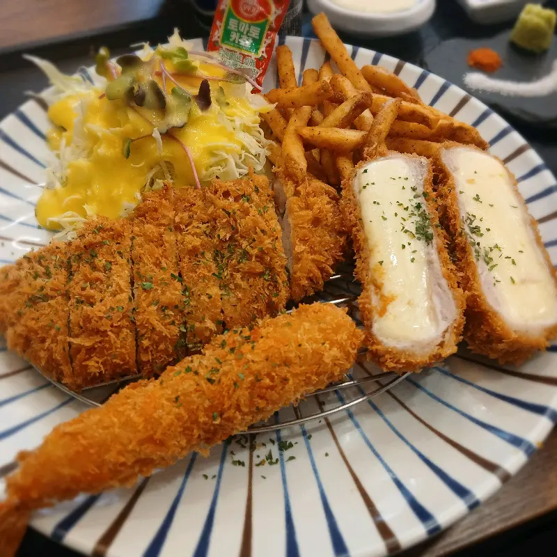 돈까스, 치즈카츠, 새우튀김, 감자튀김, 샐러드가 한 접시에 담겨있다.