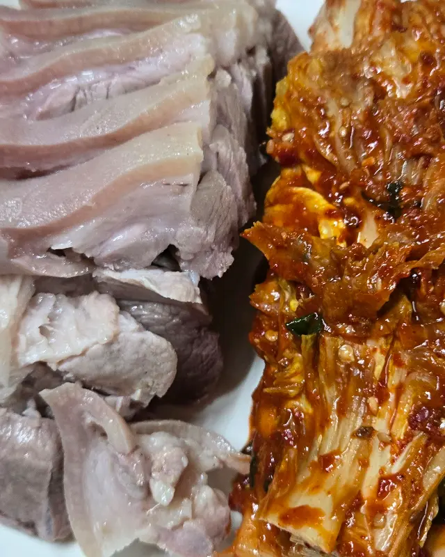 윤기가 흐르는 수육과 맛깔스러운 김치의 환상적인 조합