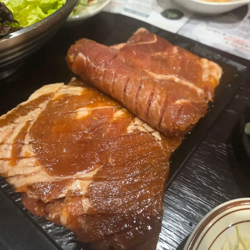 먹음직스럽게 구워진 돼지갈비와 신선한 쌈 채소