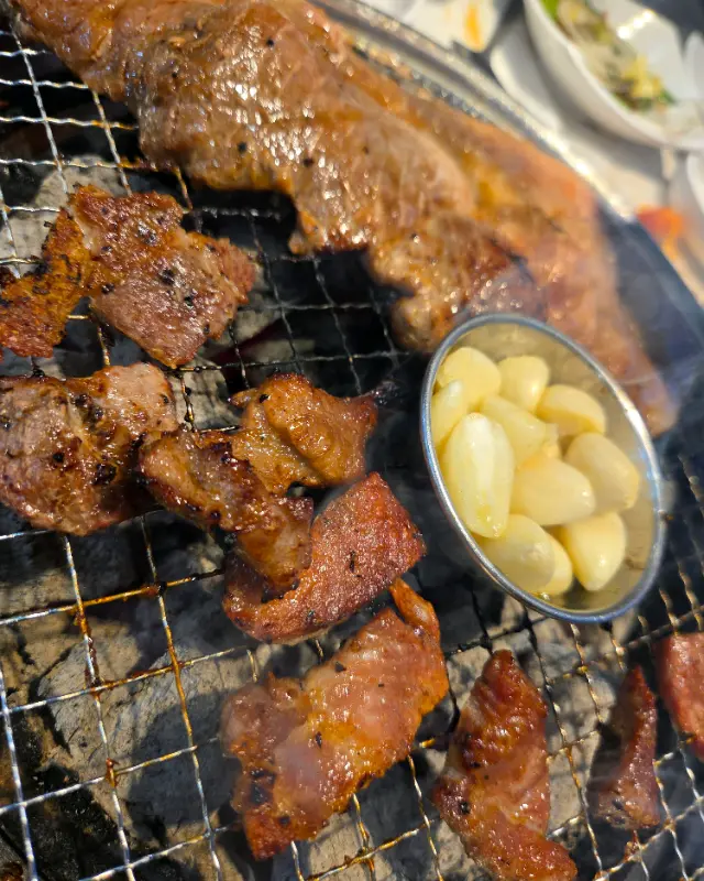 숯불 위에서 노릇하게 구워진 돼지갈비