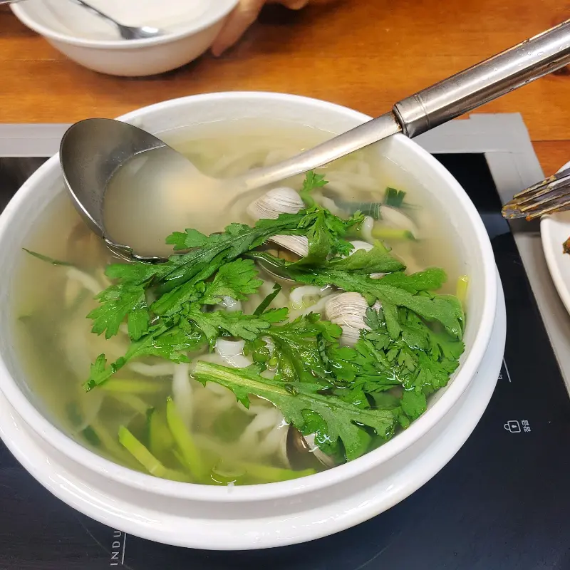 뽀얀 국물 위로 쑥갓이 듬뿍 올려진 칼국수