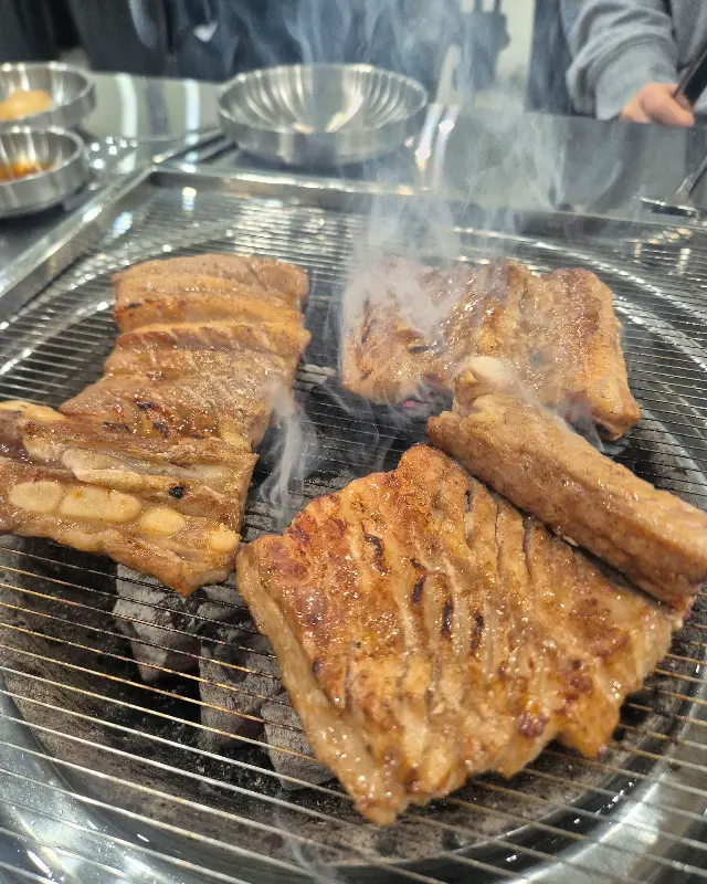 숯불 위에서 익어가는 윤슬갈비의 돼지갈비