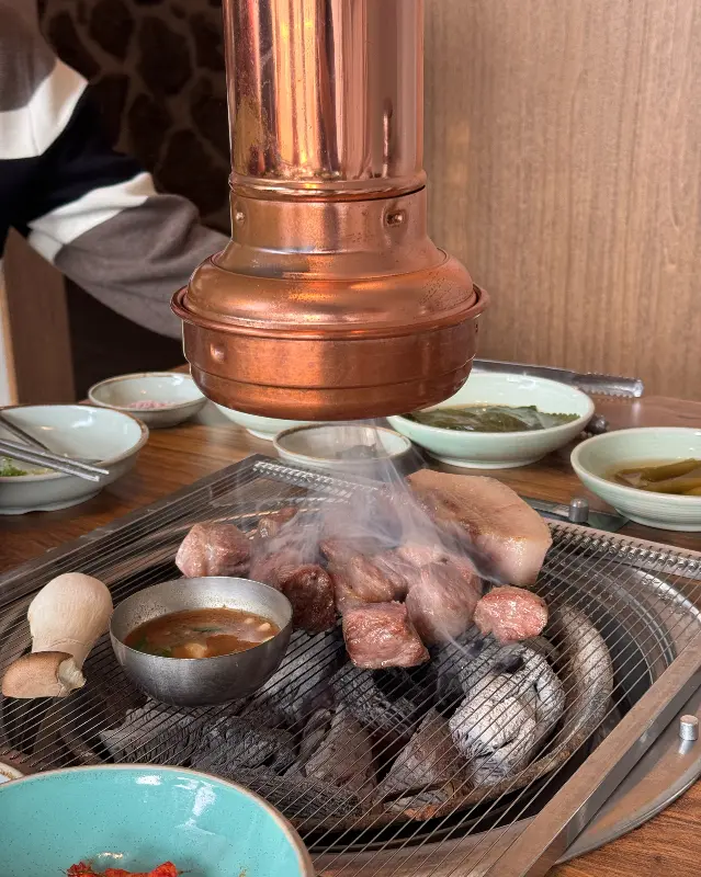 연기가 모락모락 피어오르는 숯불 위 흑돼지