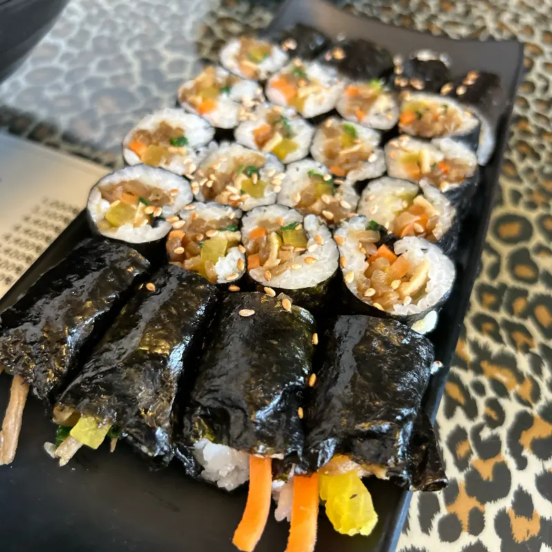 검은색 접시에 담긴 꼬마김밥과 일반 김밥