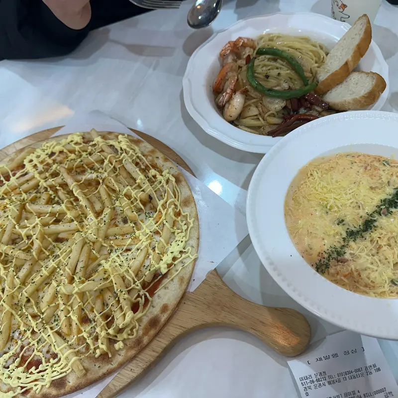 파스타, 피자, 샐러드 등 다양한 메뉴가 놓인 테이블