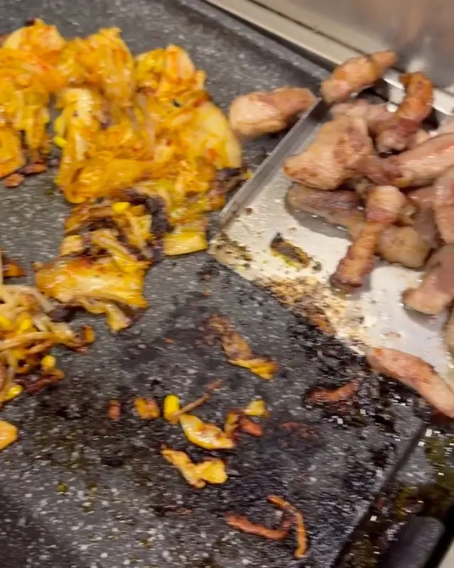 불판 위에서 김치와 콩나물이 맛있게 구워지는 모습