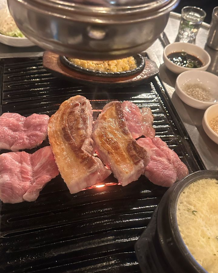 불판 위에 올려진 삼겹살과 콘치즈, 계란찜
