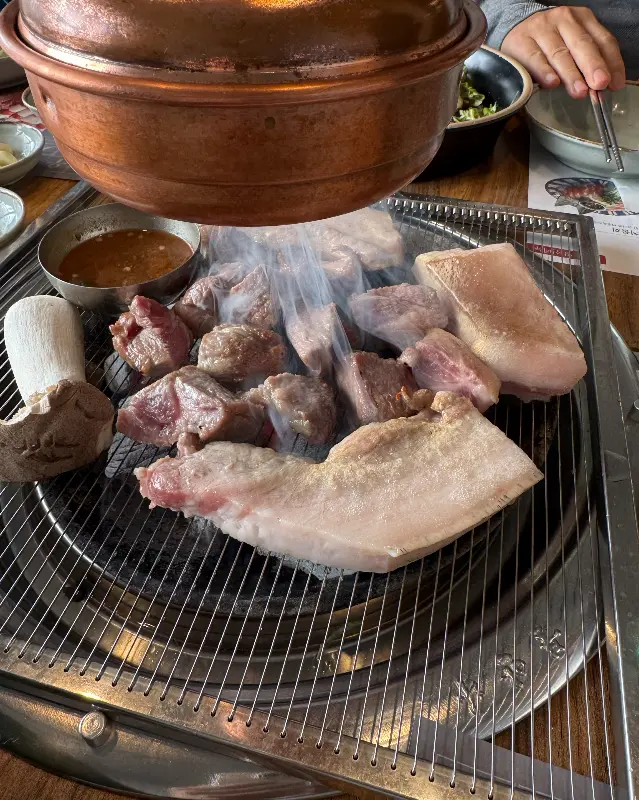 불판 위에서 익어가는 흑돼지와 버섯