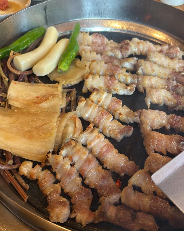삼겹살, 떡, 김치를 함께 구워먹는 모습