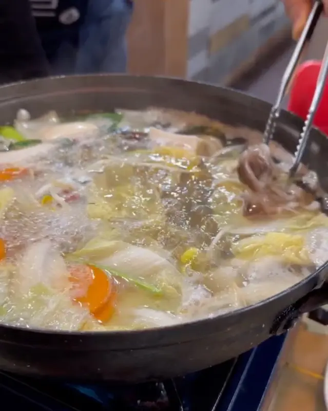 새조개를 육수에 살짝 담그는 모습