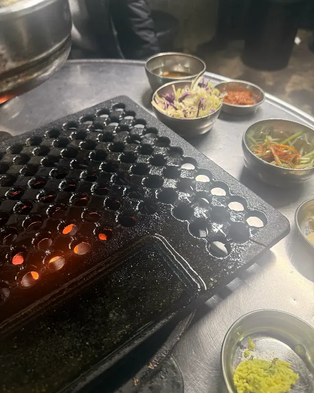 연탄불 화로와 스테인리스 그릇에 담긴 소스들