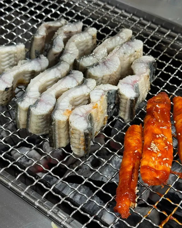 숯불 위에서 구워지는 장어와 더덕구이