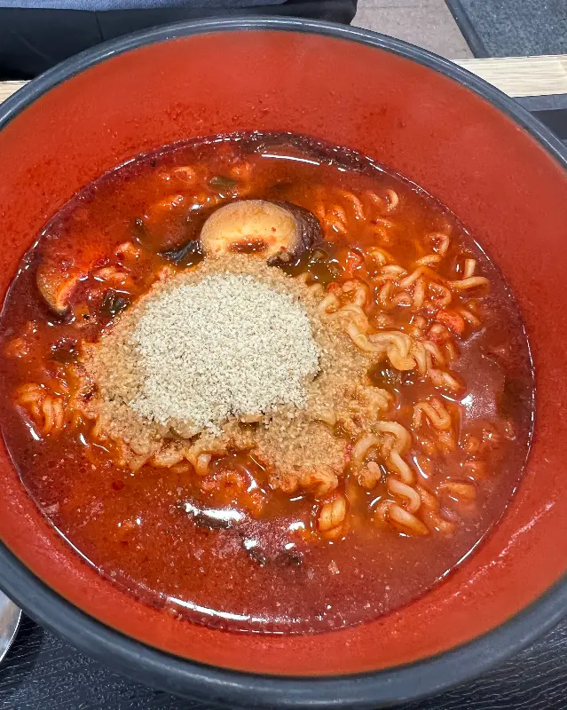들깨가루가 듬뿍 뿌려진 빨간 국물의 라면