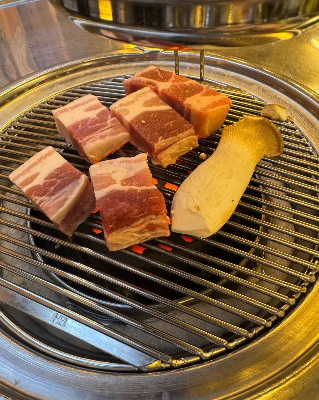 삼겹살과 팽이버섯이 구워지는 모습